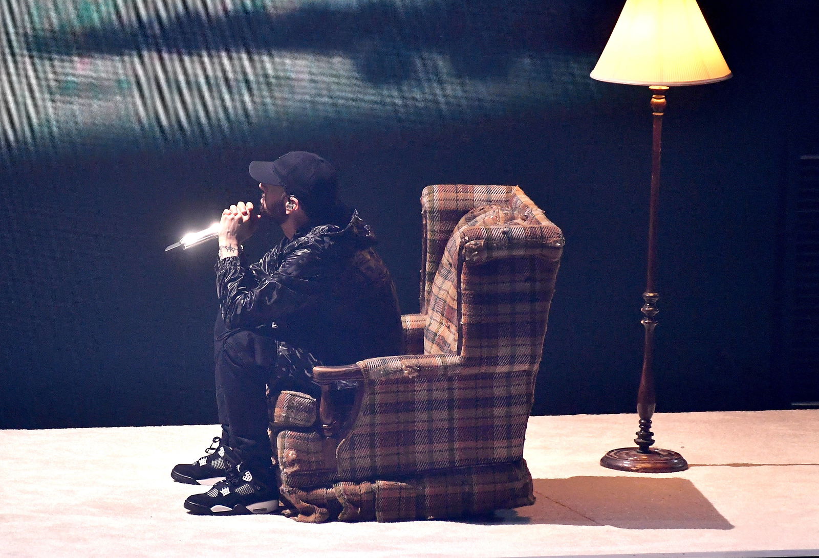 Eminem sitzt auf der Bühne in einem Sessel 