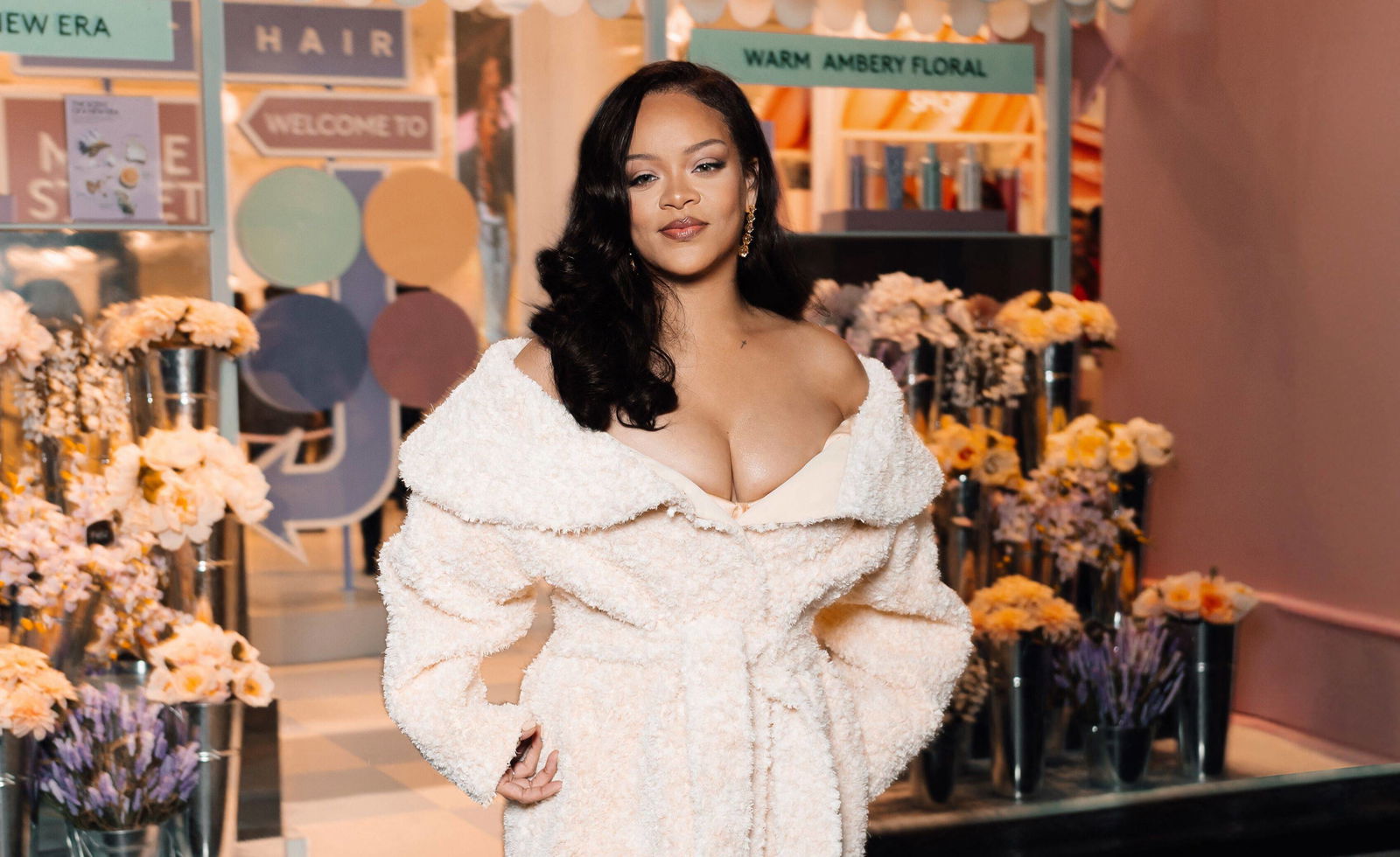 Rihanna in einem weißes Mantel vor einem Blumengeschäft