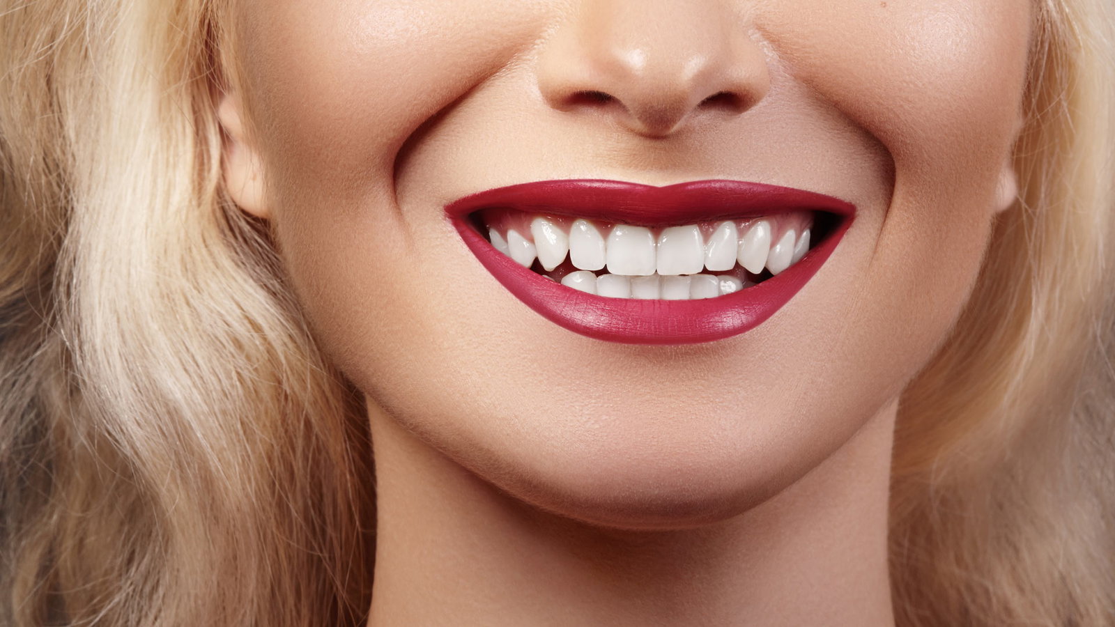 Person mit perfekten Zähnen lächelt in die Kamera