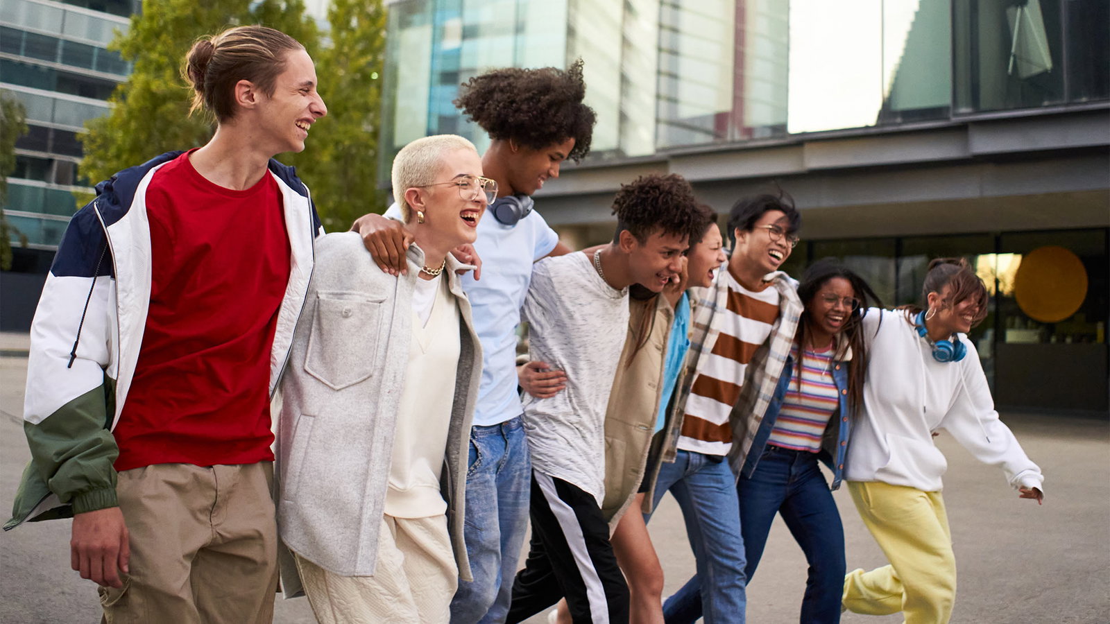 Eine Gruppe Jugendlicher läuft lachend durch die Stadt