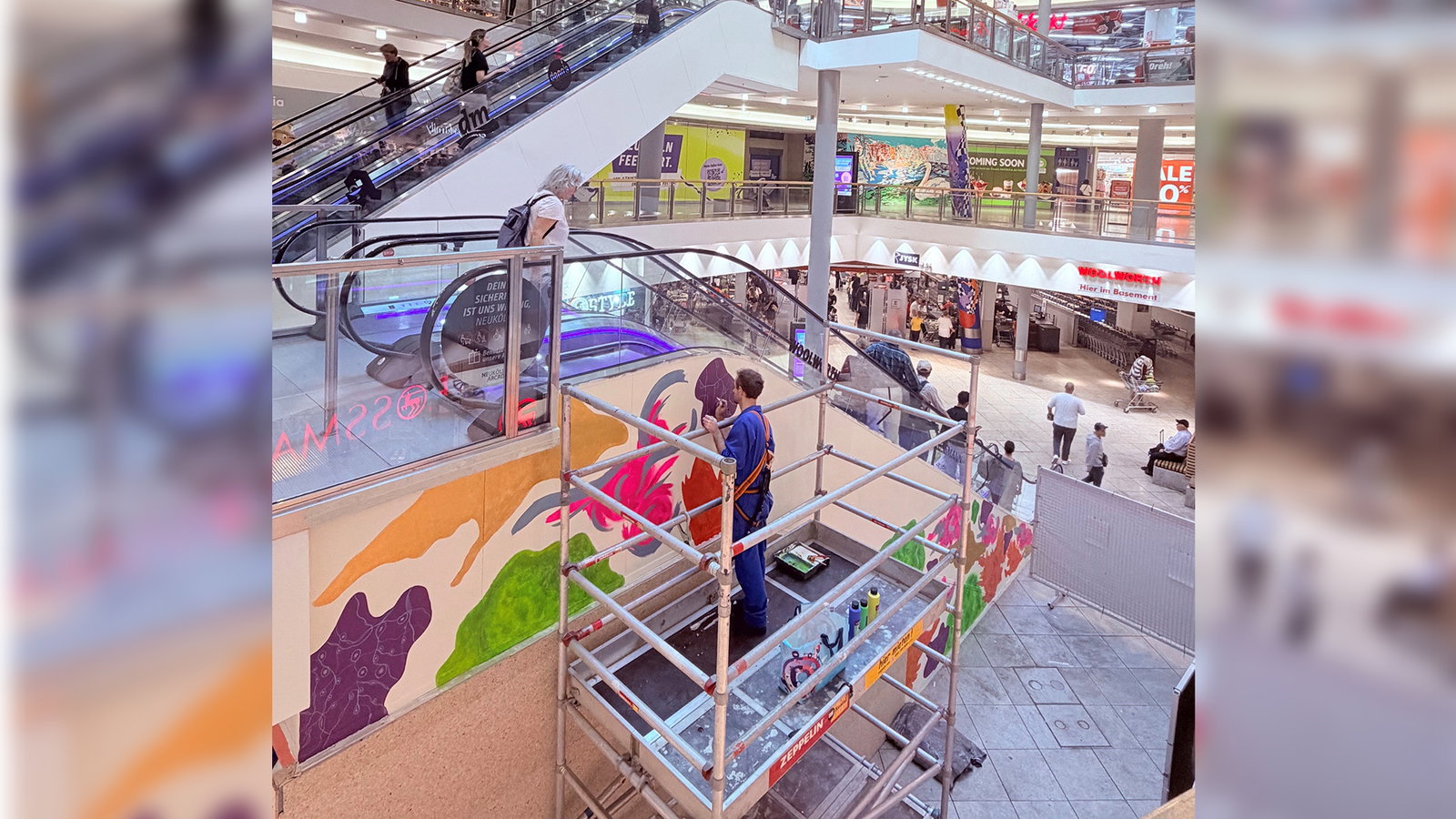 Bild von den Neukölln Arcaden innen mit Gerüst und Künstler