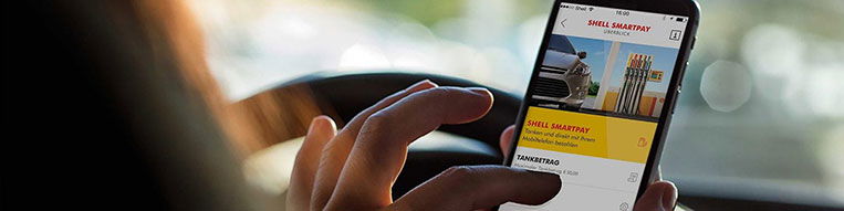 a car driver is checking the shell motorist app